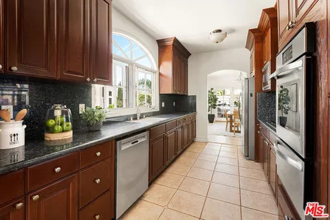 a large kitchen with stainless steel appliances granite countertop a refrigerator and a sink