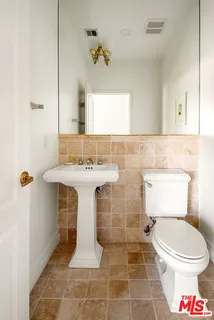 a bathroom with a sink toilet and mirror