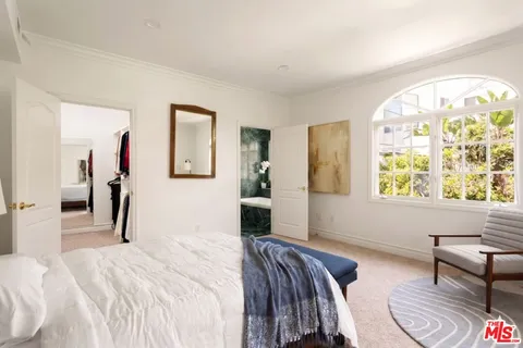 a bedroom with a bed and a painting on the wall