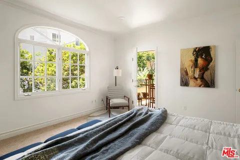 a bedroom with furniture and a large window