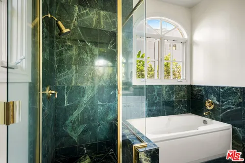 a bathroom with a white bath tub and a shower