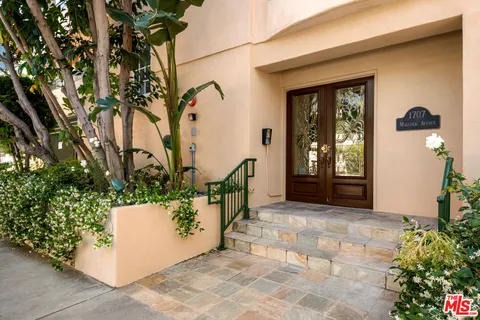 a view of a door and chair in front of house