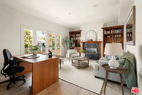 a living room with furniture a rug potted plant and a large window
