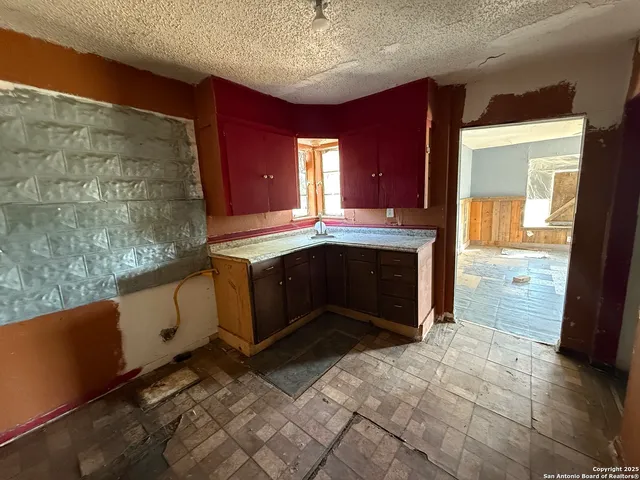 a view of kitchen with granite countertop cabinets and sink