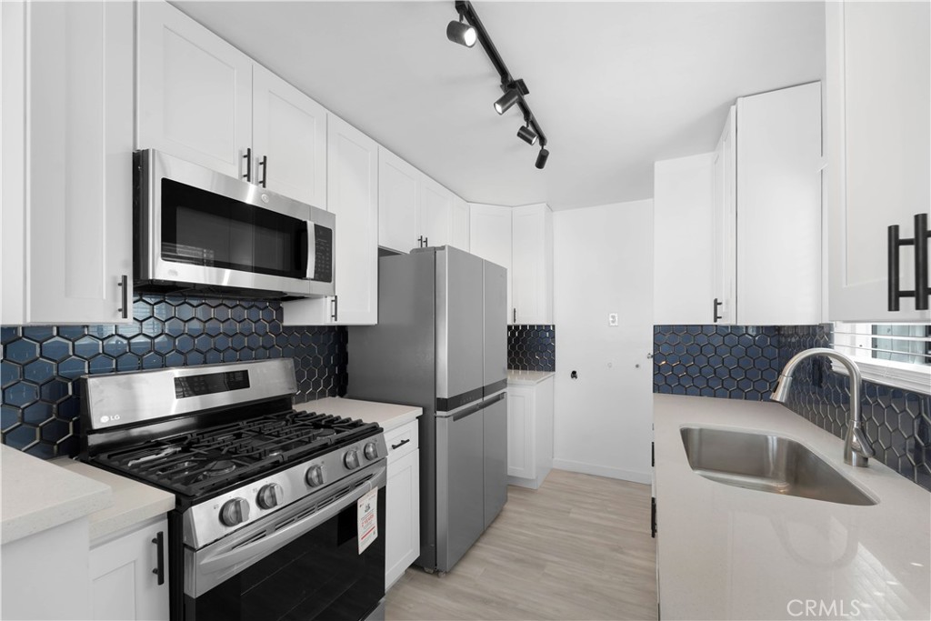 1836 Sunrise Road Barstow, CA 92311 - Photo 2 of 16 a kitchen with stainless steel appliances a stove a microwave and a refrigerator