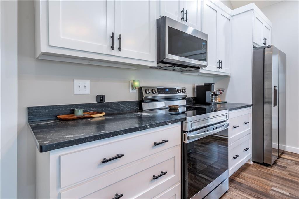 110 Burnt Mountain Cove Road Jasper, GA 30143 - Photo 21 of 33 a kitchen with stainless steel appliances granite countertop a sink a stove and a microwave