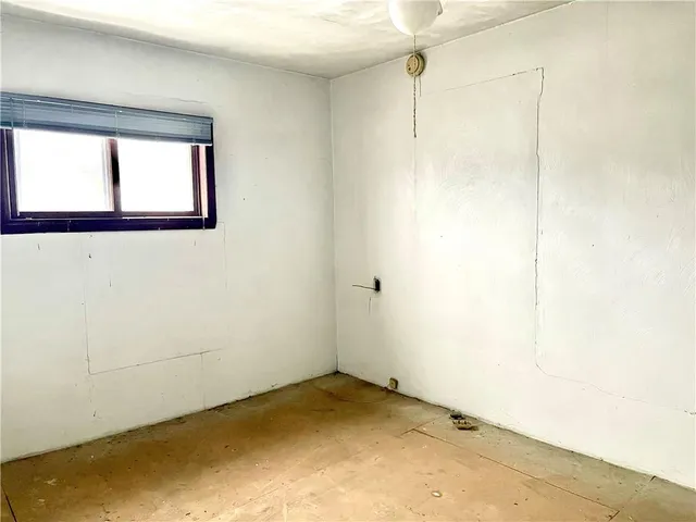 a view of a small space with wooden floor and a window