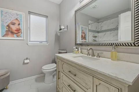 a bathroom with a granite countertop toilet sink and mirror