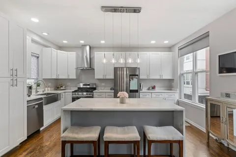 a kitchen with kitchen island granite countertop a sink and stove