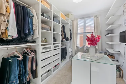 a view of walk in closet with clothes and shoes
