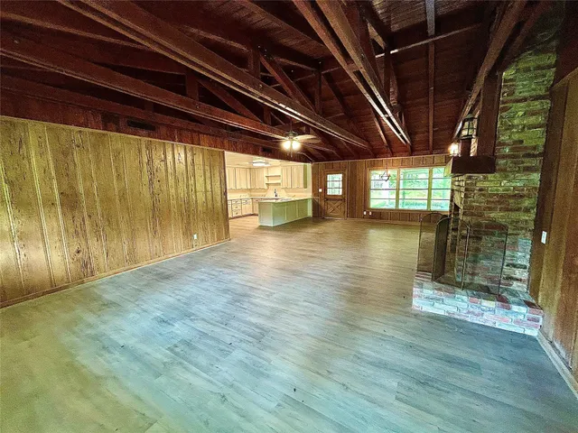 a view of empty room with wooden floor and floor to ceiling window