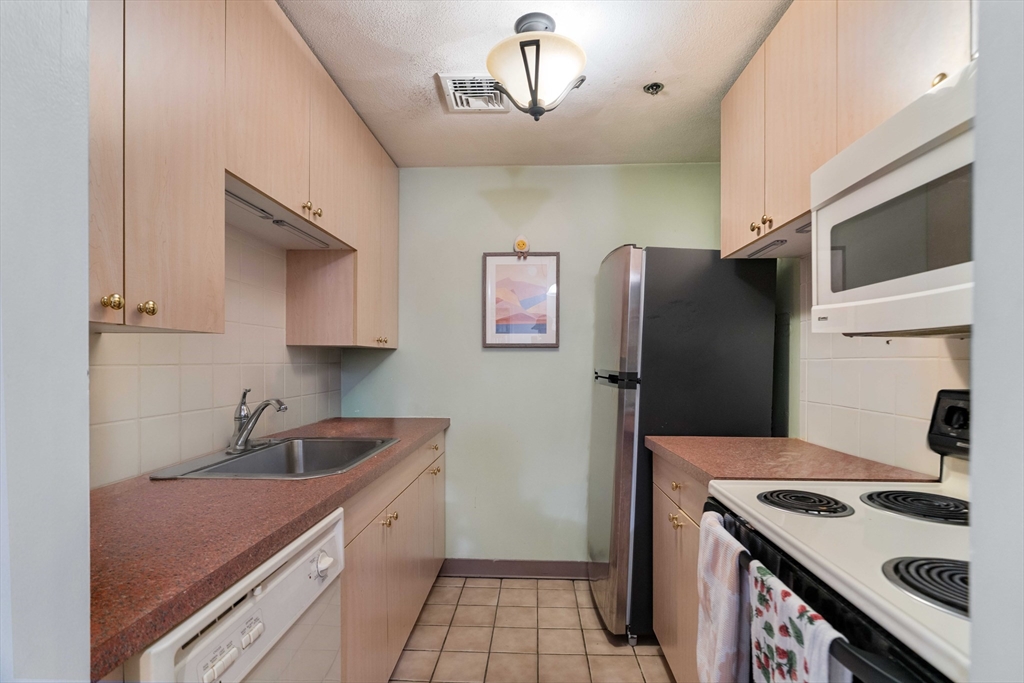 188 North Street, Unit 53 Boston, MA 02113 - Photo 3 of 14 a kitchen with stainless steel appliances granite countertop a refrigerator and a sink