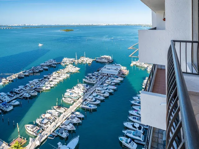 a front view of a building with glass windows and a yard
