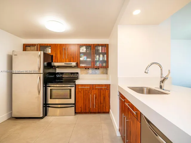 a kitchen with stainless steel appliances granite countertop a refrigerator sink and stove