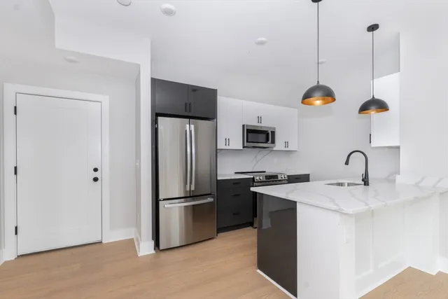 a kitchen with stainless steel appliances granite countertop a sink a stove and a refrigerator