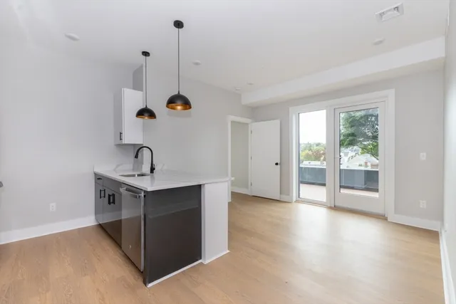 a view of a kitchen with a sink wooden floor and a window