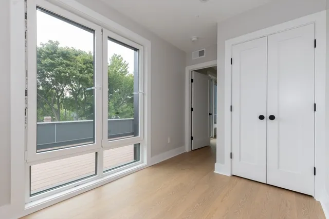 a view of an empty room with a window and a ceiling fan
