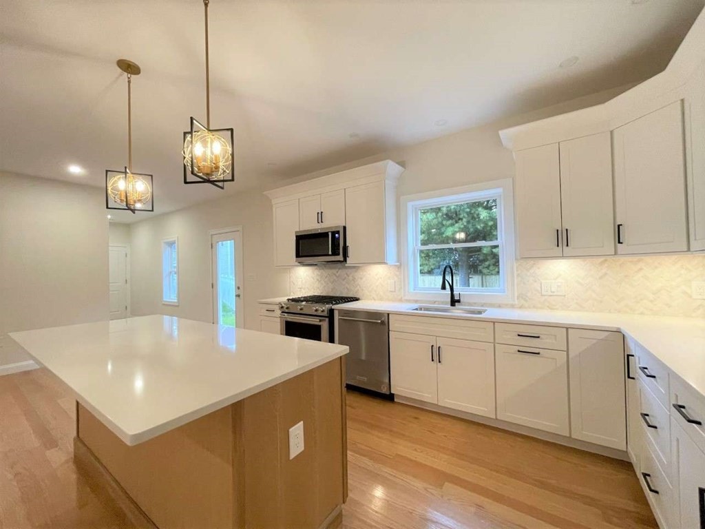 28 Line Road, Unit 1 Wakefield, MA 01880 - Photo 5 of 20 a large kitchen with stainless steel appliances granite countertop a sink a stove and a wooden floors