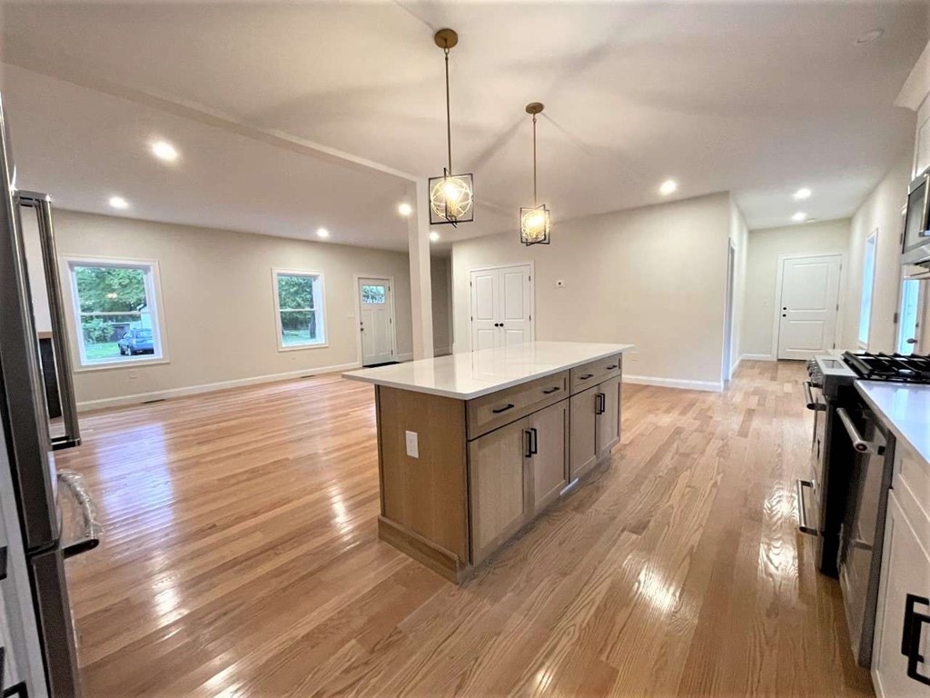 28 Line Road, Unit 1 Wakefield, MA 01880 - Photo 8 of 20 a kitchen with stainless steel appliances granite countertop a stove a sink a refrigerator and a wooden floor