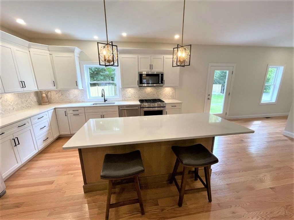 28 Line Road, Unit 1 Wakefield, MA 01880 - Photo 9 of 20 a kitchen with kitchen island a dining table chairs cabinets and stainless steel appliances