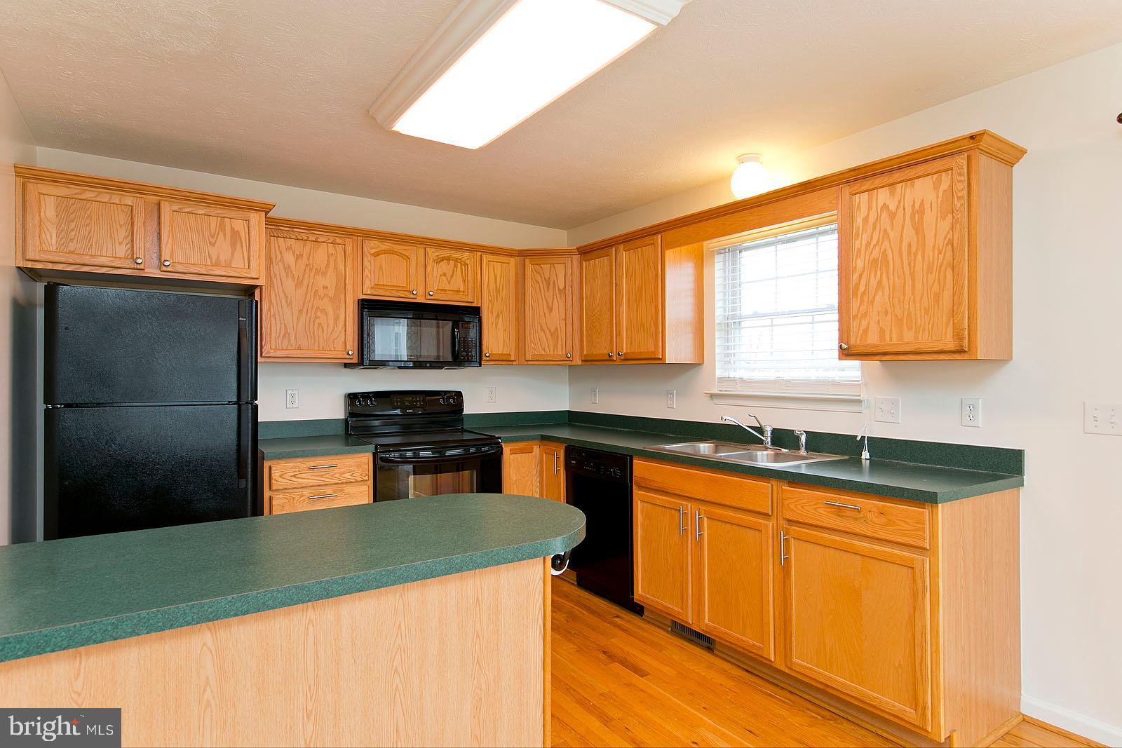 100 Scirocco Lane Winchester, VA 22602 - Photo 14 of 37 a kitchen with stainless steel appliances granite countertop a sink stove microwave and refrigerator