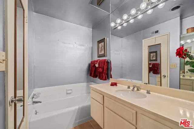a bathroom with a tub sink and mirror