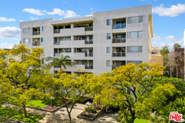 a view of a building with a yard and sitting area