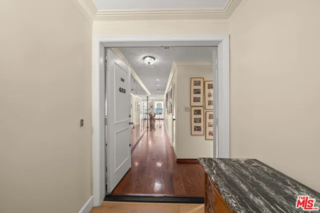 a view of a hallway with wooden floor and stairs