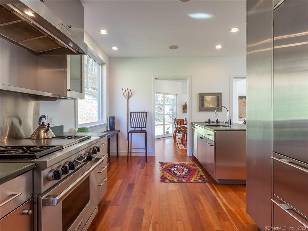 151 Treasure Hill Road Kent, CT 06785 - Photo 12 of 25 a kitchen with kitchen island wooden floors appliances and white cabinets
