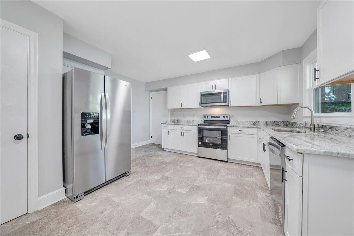 547 Dillard Road Southwest Roanoke, VA 24014 - Photo 5 of 26 a kitchen with stainless steel appliances granite countertop a stove a sink and a refrigerator