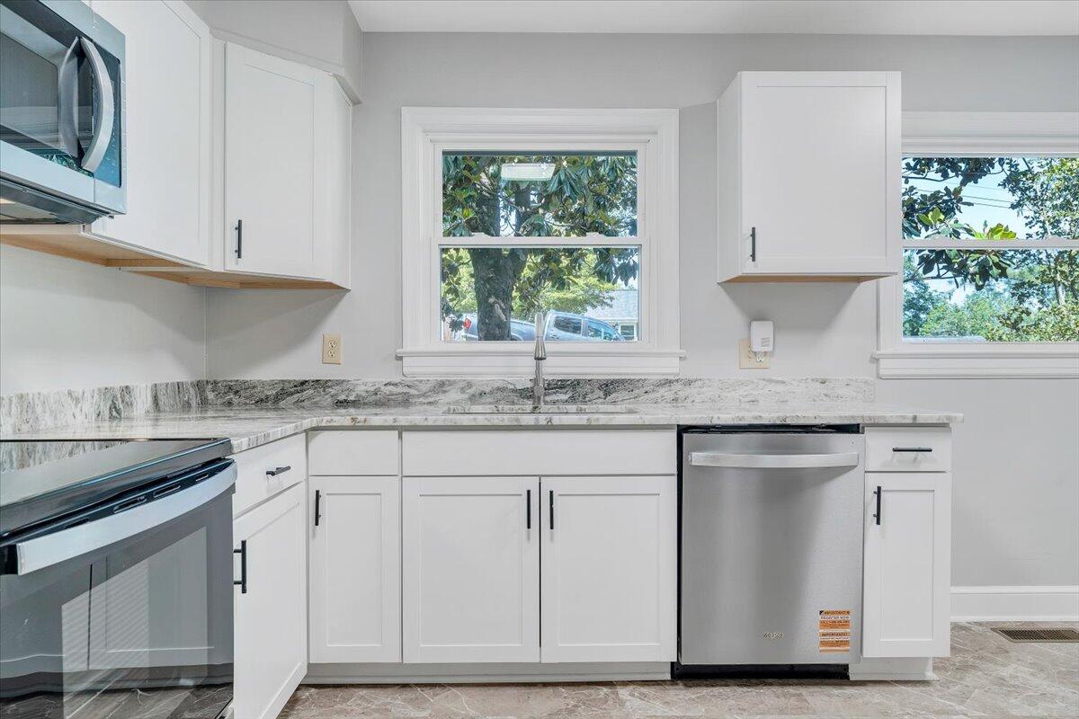 547 Dillard Road Southwest Roanoke, VA 24014 - Photo 7 of 26 a kitchen with granite countertop white cabinets white appliances a sink and a window