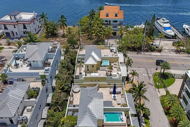 a bedroom with a bed a dresser and large windows