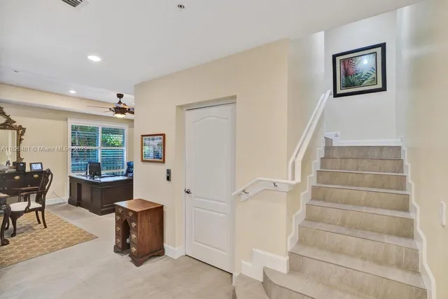a bedroom with a bed ceiling fan and a wooden floor