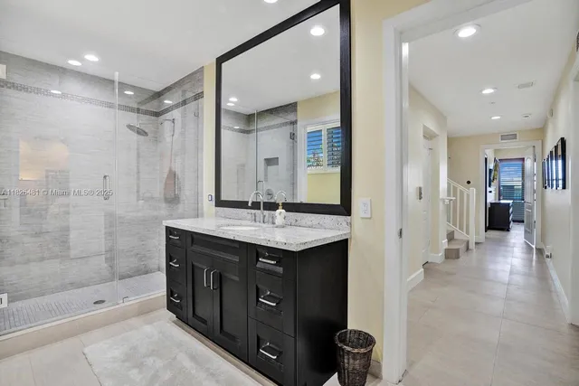 a view of a patio with couches table and chairs under an umbrella with a barbeque grill and plants