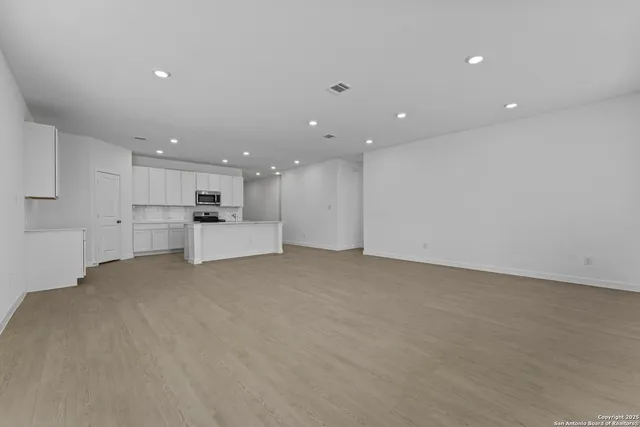 a view of an empty room with kitchen appliances