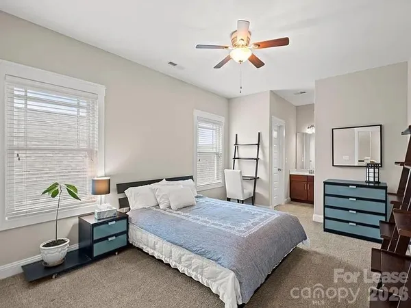 a bedroom with a bed a chandelier and a dresser