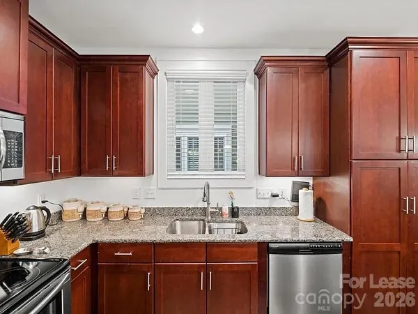 a kitchen with stainless steel appliances granite countertop a sink stove and cabinets