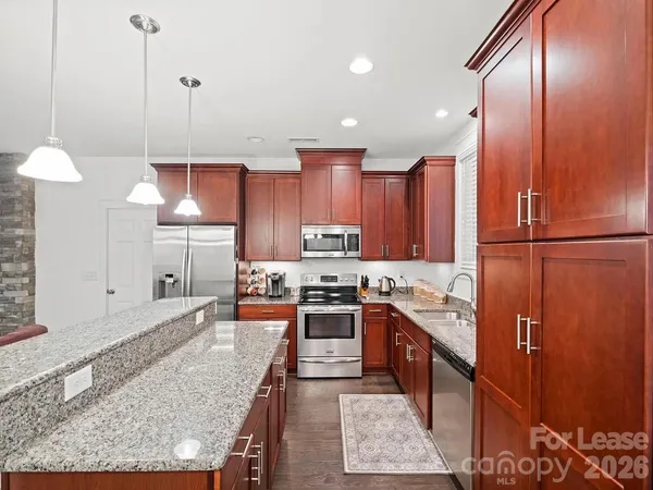 a kitchen with stainless steel appliances granite countertop a stove a sink a refrigerator and a oven