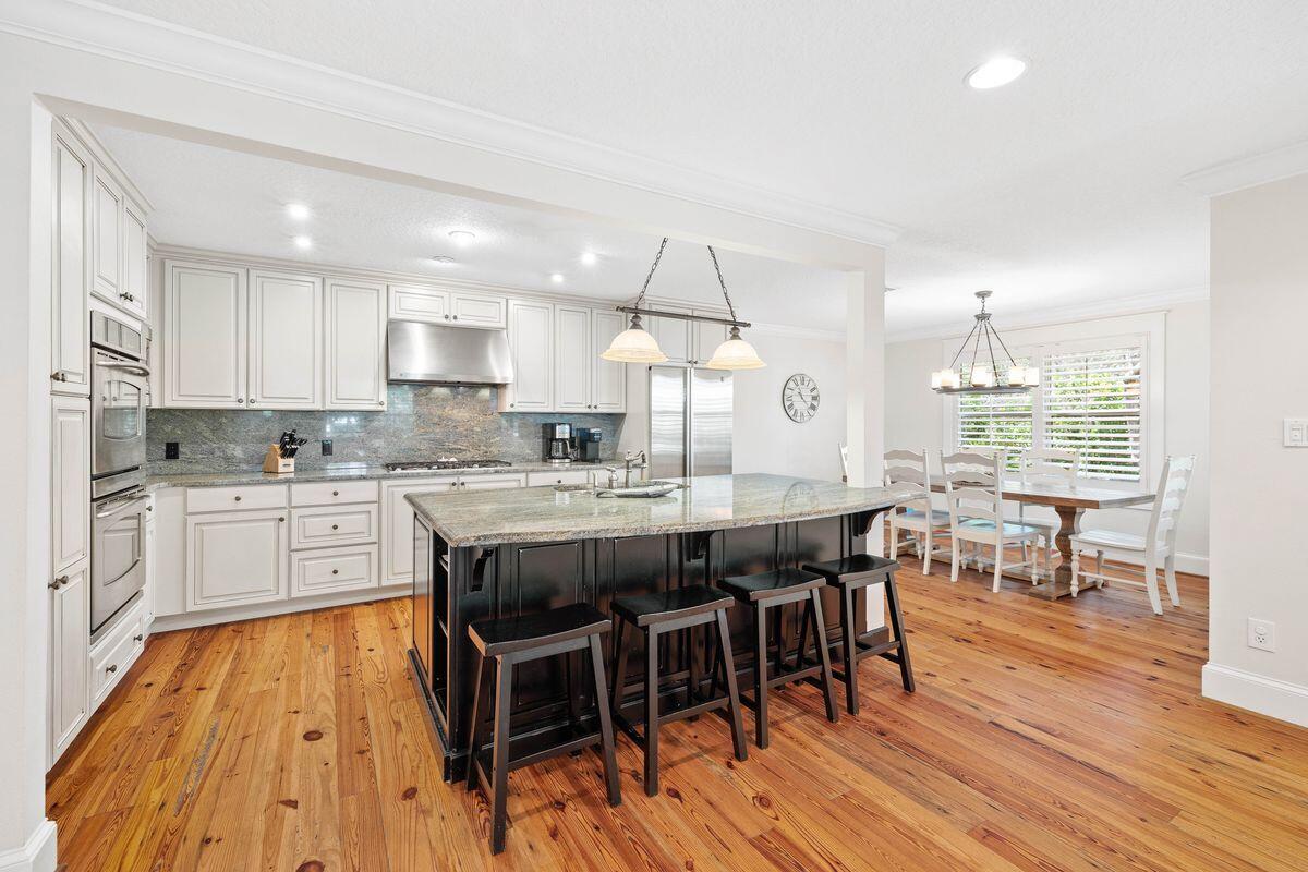 141 Crescent Road Santa Rosa Beach, FL 32459 - Photo 4 of 40 a large kitchen with kitchen island a island a stove a table and chairs in it