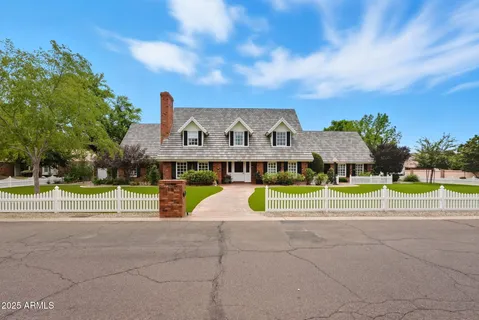 a view of a house with a big yard and large trees