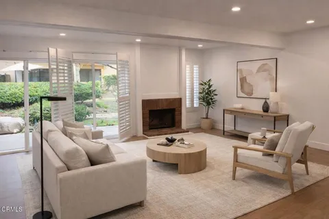 a living room with furniture a fireplace and a floor to ceiling window