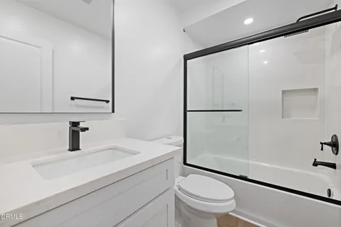 a bathroom with a sink a toilet and a large mirror