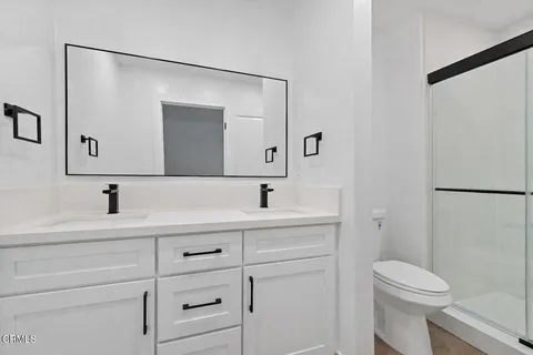a bathroom with a sink a toilet and a mirror