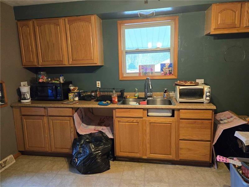 104 Forrest Street Petrolia, PA 16050 - Photo 5 of 22 a kitchen with stainless steel appliances granite countertop a stove a sink and a microwave