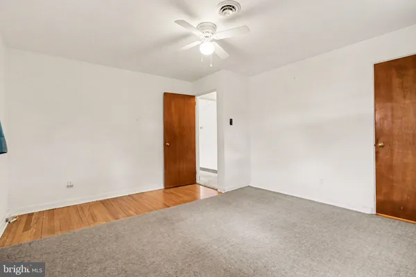 an empty room with a ceiling fan and a window