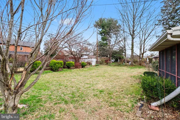 a front view of house with yard and trees in the background