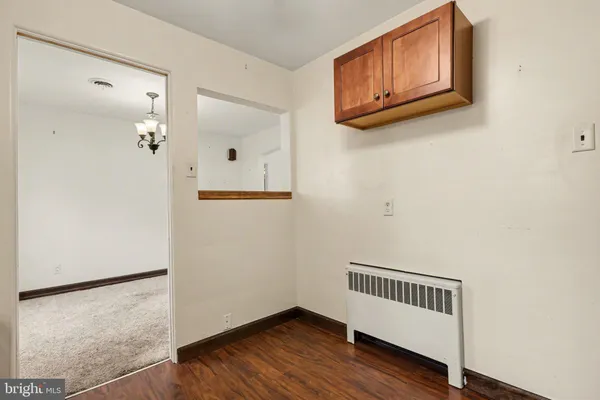 a view of a hallway with wooden floor and cabinet