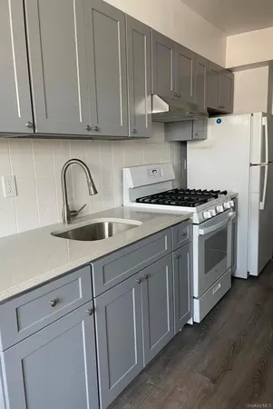 a kitchen with stainless steel appliances granite countertop a sink a stove and refrigerator