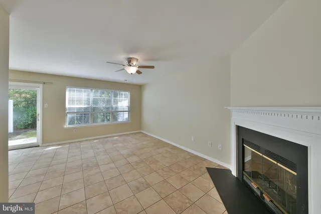 a view of an empty room with a fireplace and a window