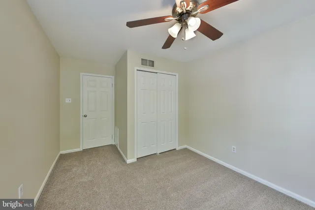 an empty room with a fan and a fan